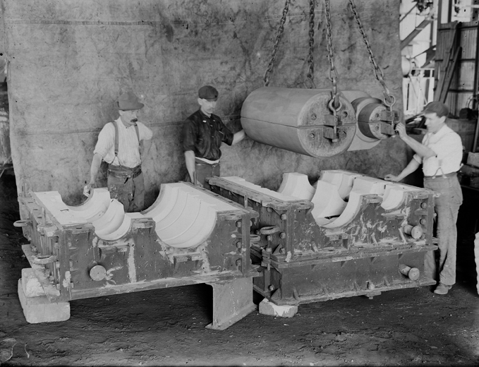 Photograph of three foundry men and large moulding box