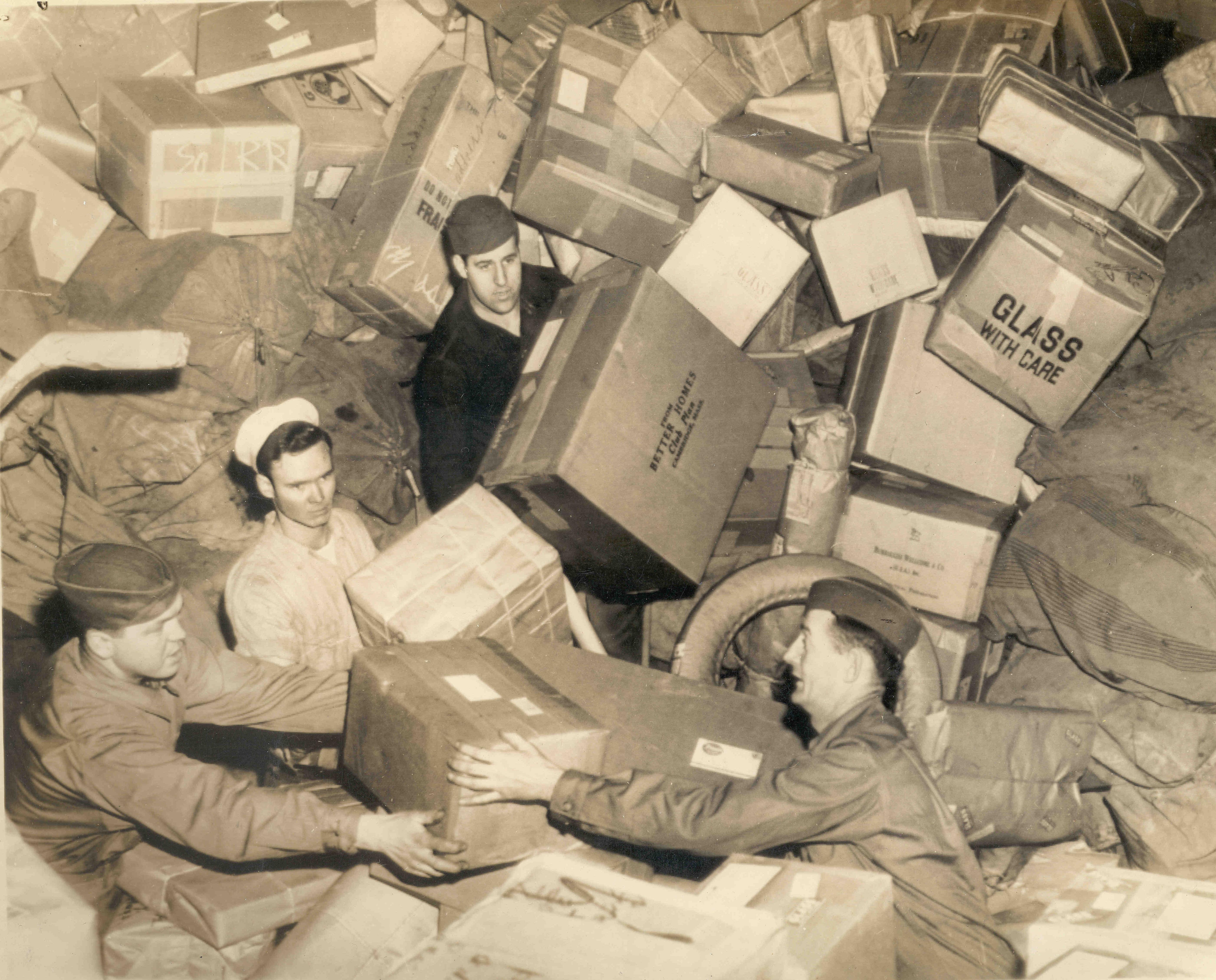 U.S. troops almost buried by parcels do their best to handle that year's holiday mail